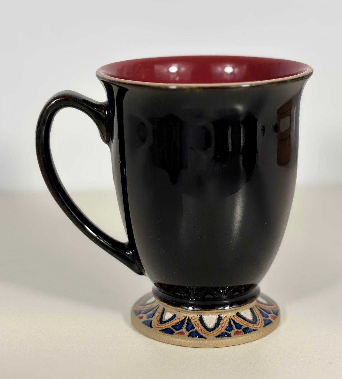 Black mug with a decorative base on a white background