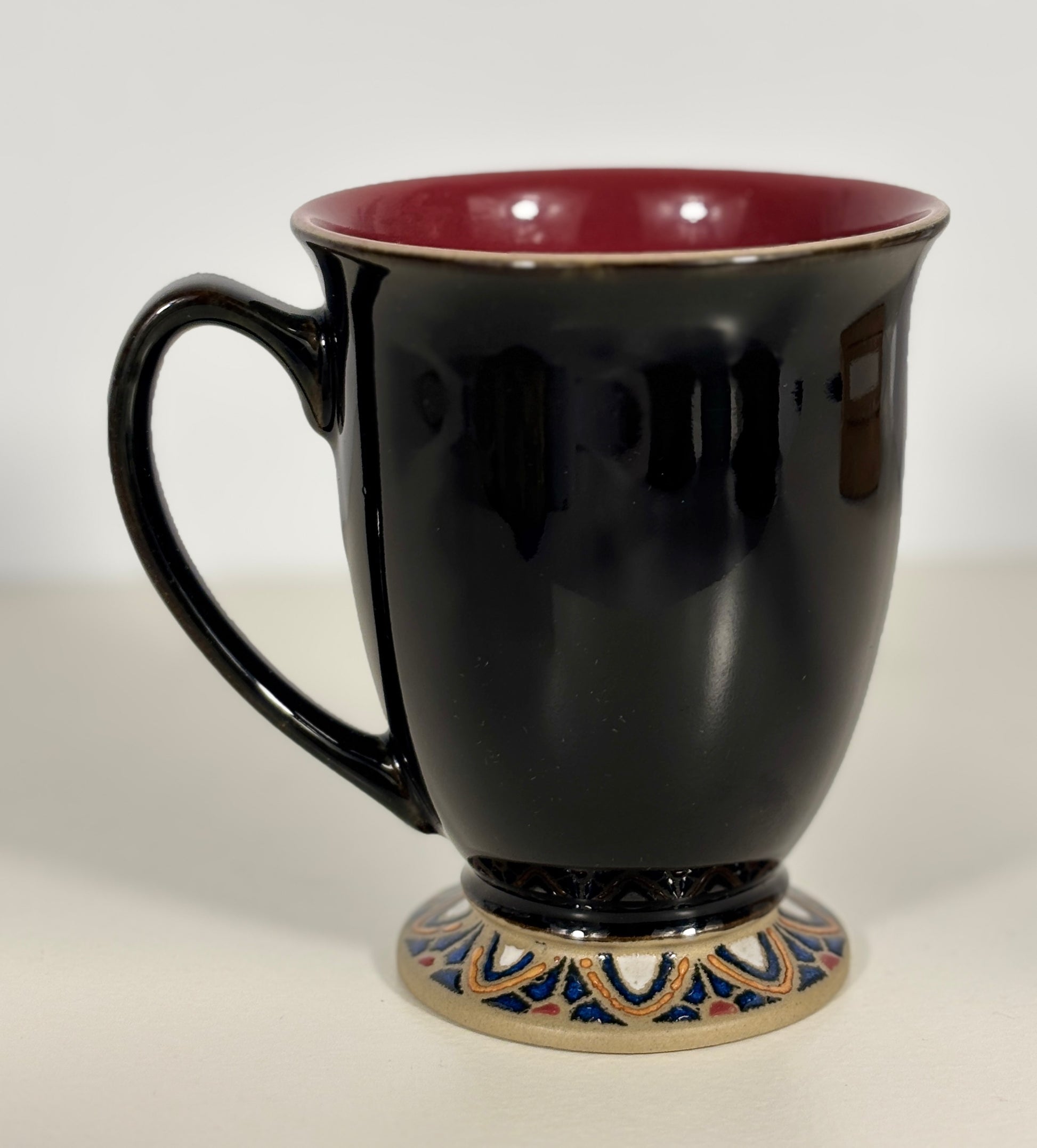 Black mug with a decorative base on a white background