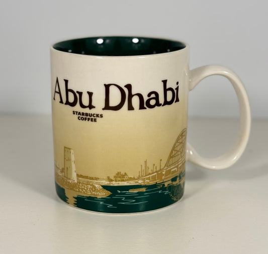Starbucks coffee mug with 'Abu Dhabi' branding on a plain background
