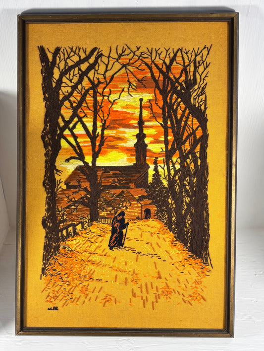 Framed artwork of a silhouette of a church and trees at sunset.