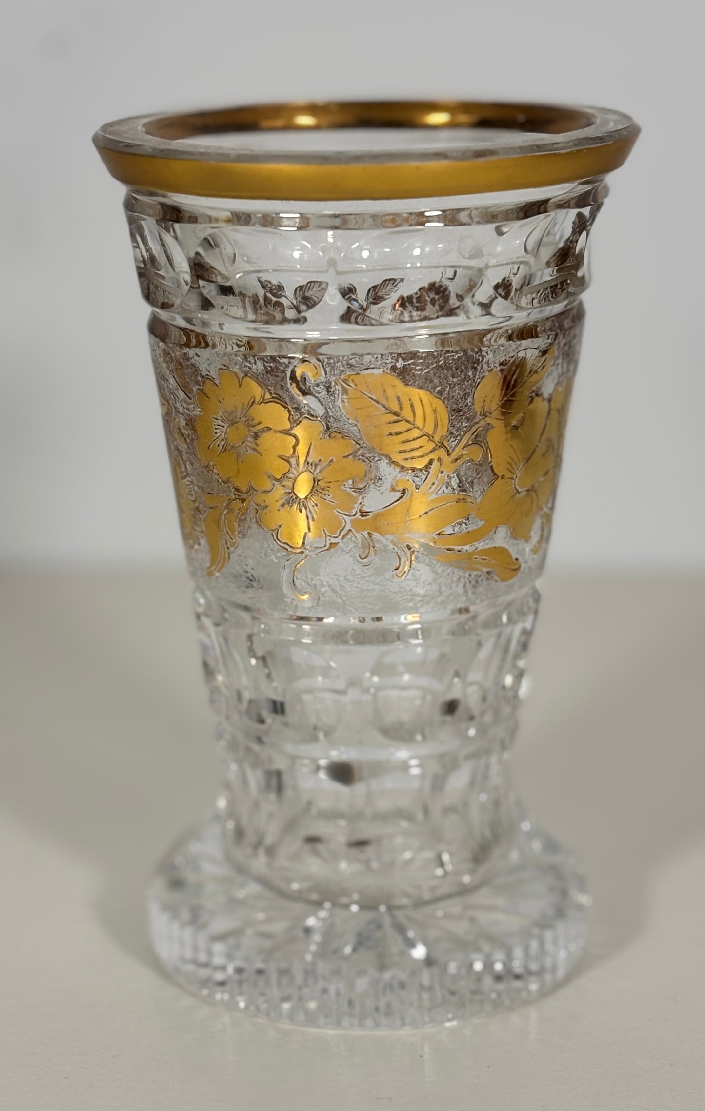 Decorative glass with gold floral patterns on a white background