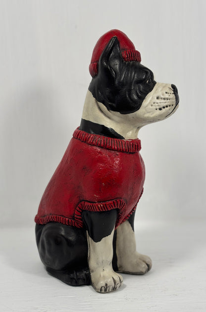 Dog figurine wearing a red sweater and hat on a white background
