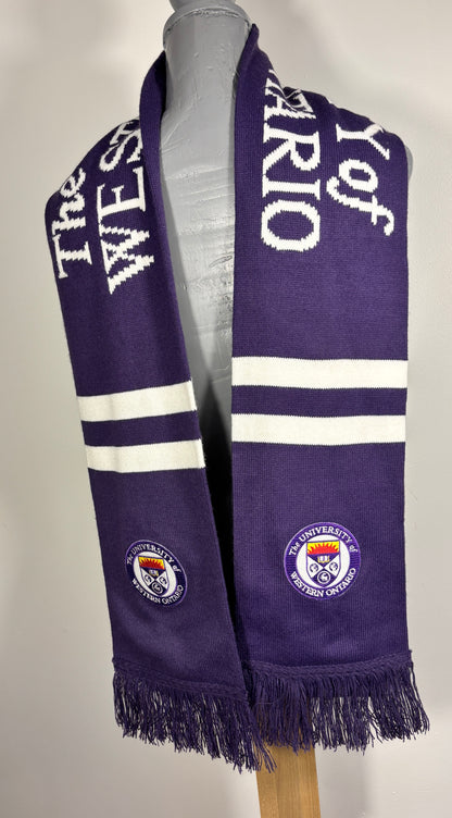 Purple scarf with white text and logos on a mannequin against a gray background