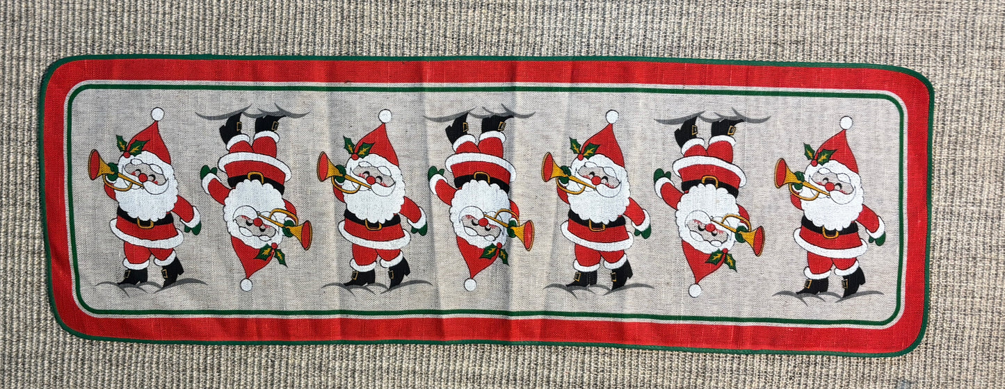 Decorative table runner with Santa Claus illustrations on a textured surface