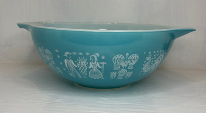 Turquoise bowl with white decorative patterns on a light gray background