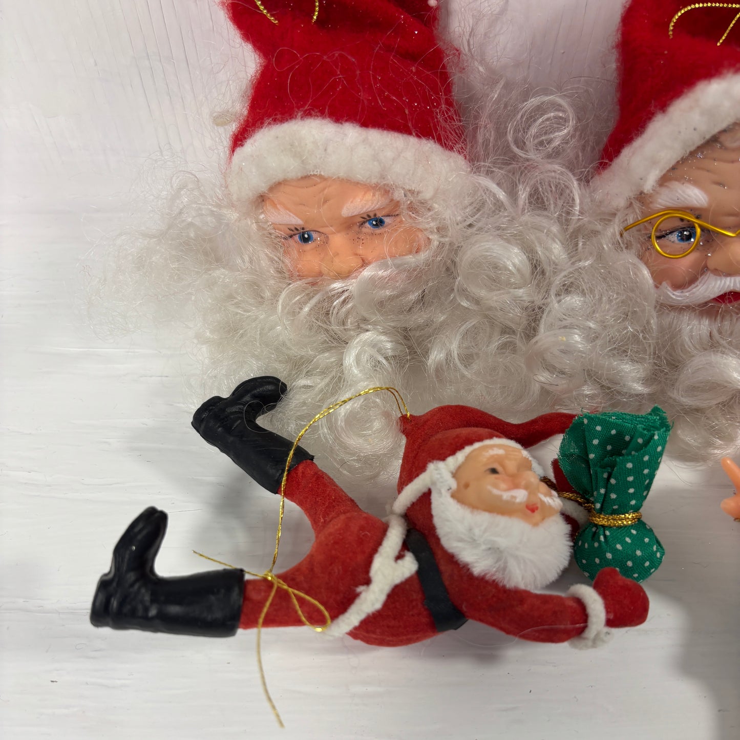 Decorative figurines of Santa Claus with a smaller figure in the foreground on a white background