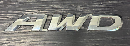 Metallic 'AWD' emblem on a dark background