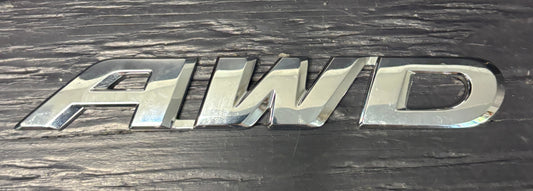 Metallic 'AWD' emblem on a dark background