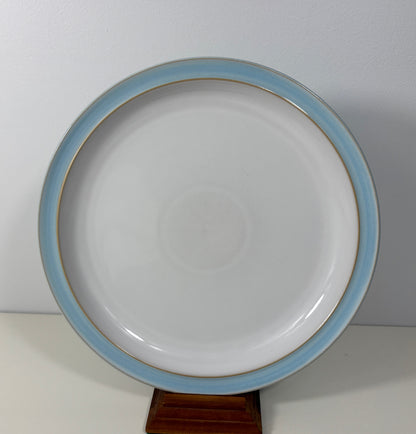 White plate with blue rim on a stand against a white background