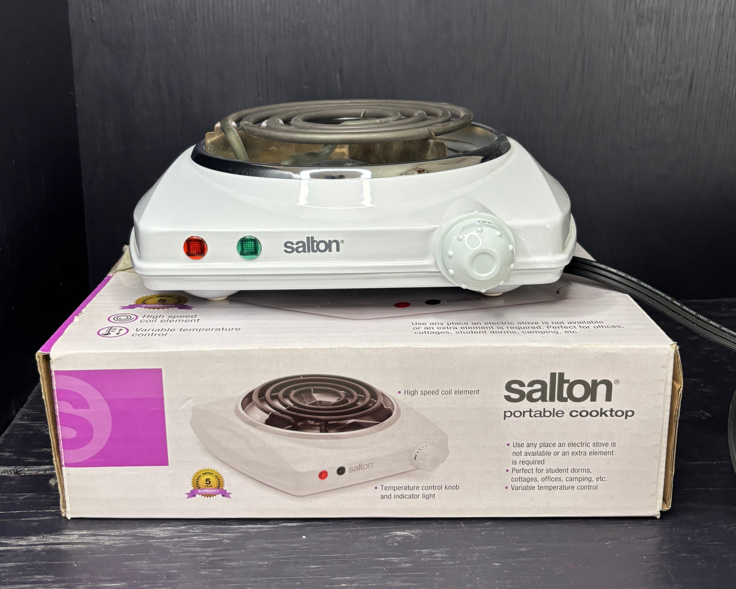 Salton portable cooktop on top of its packaging box with a dark background