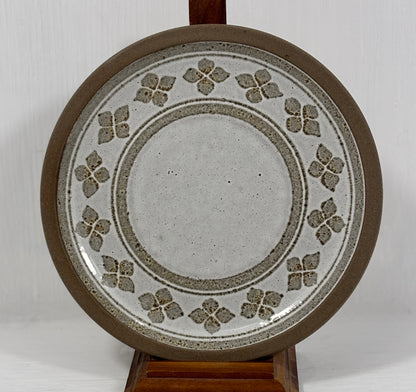 Ceramic plate with decorative pattern on a stand against a white background