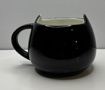 Black cat-shaped mug on a light gray background