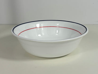 White bowl with red and blue rim on a white background