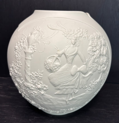 Decorative white ceramic plate with embossed design on a dark background