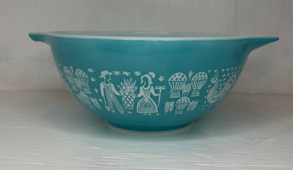 Teal bowl with white decorative patterns on a light gray background