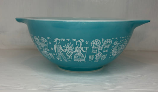 Teal bowl with white decorative patterns on a light gray background