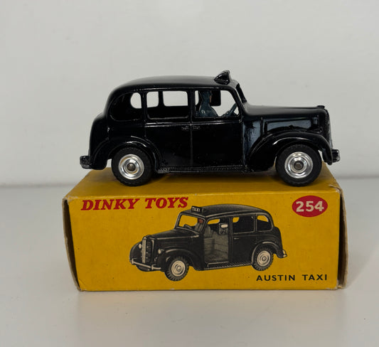 Black toy Austin taxi on a Dinky Toys box with '254' and 'Dinky Toys' branding.