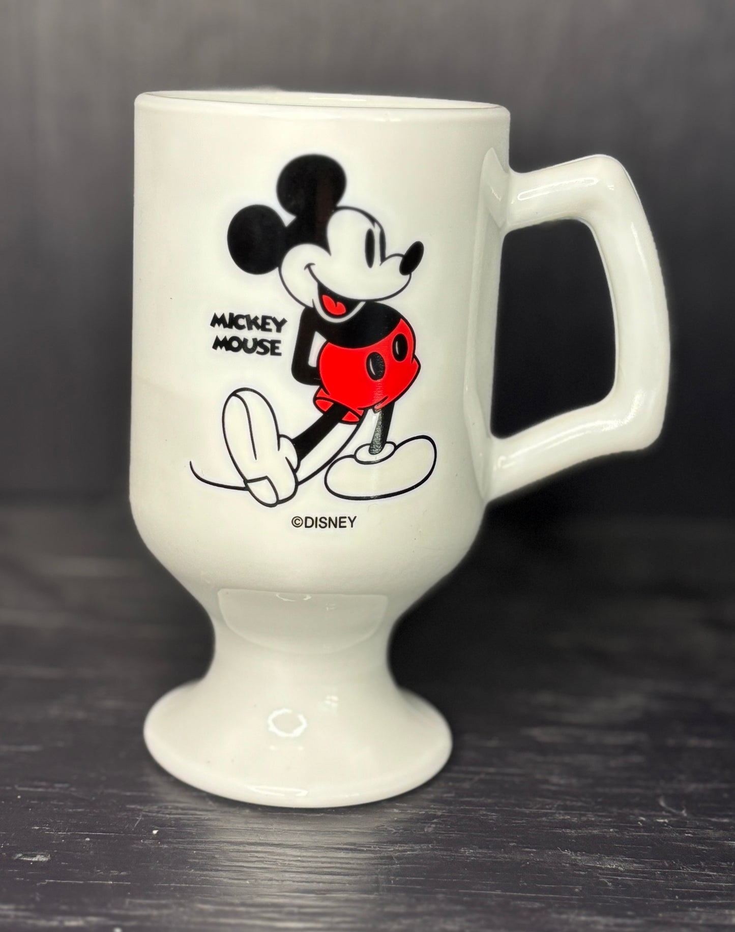 White mug with Mickey Mouse design on a dark background