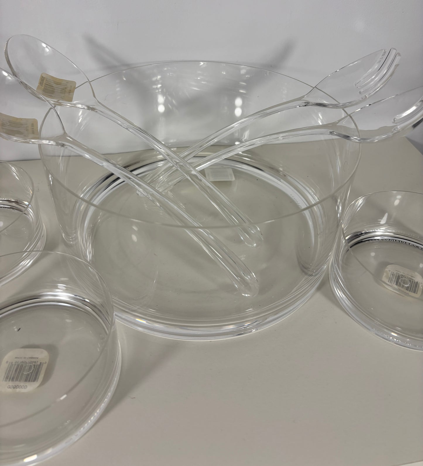 Clear plastic bowls and forks on a white surface
