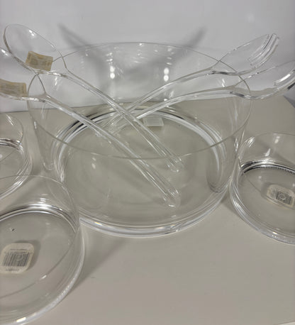 Clear plastic bowls and forks on a white surface