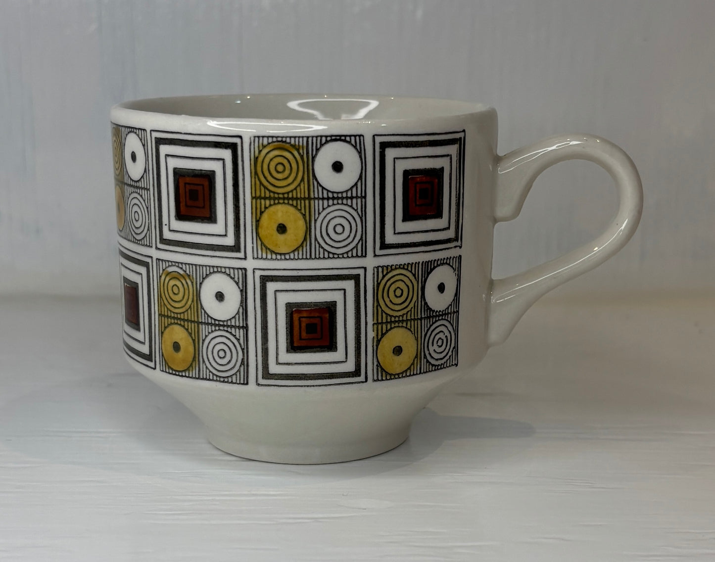 White mug with geometric pattern on a light gray background
