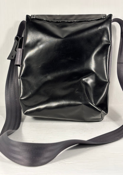 Black leather crossbody bag on a light gray background
