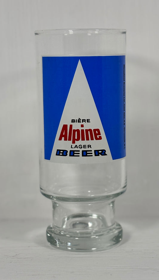 Clear glass with Alpine Lager Beer label on a white background