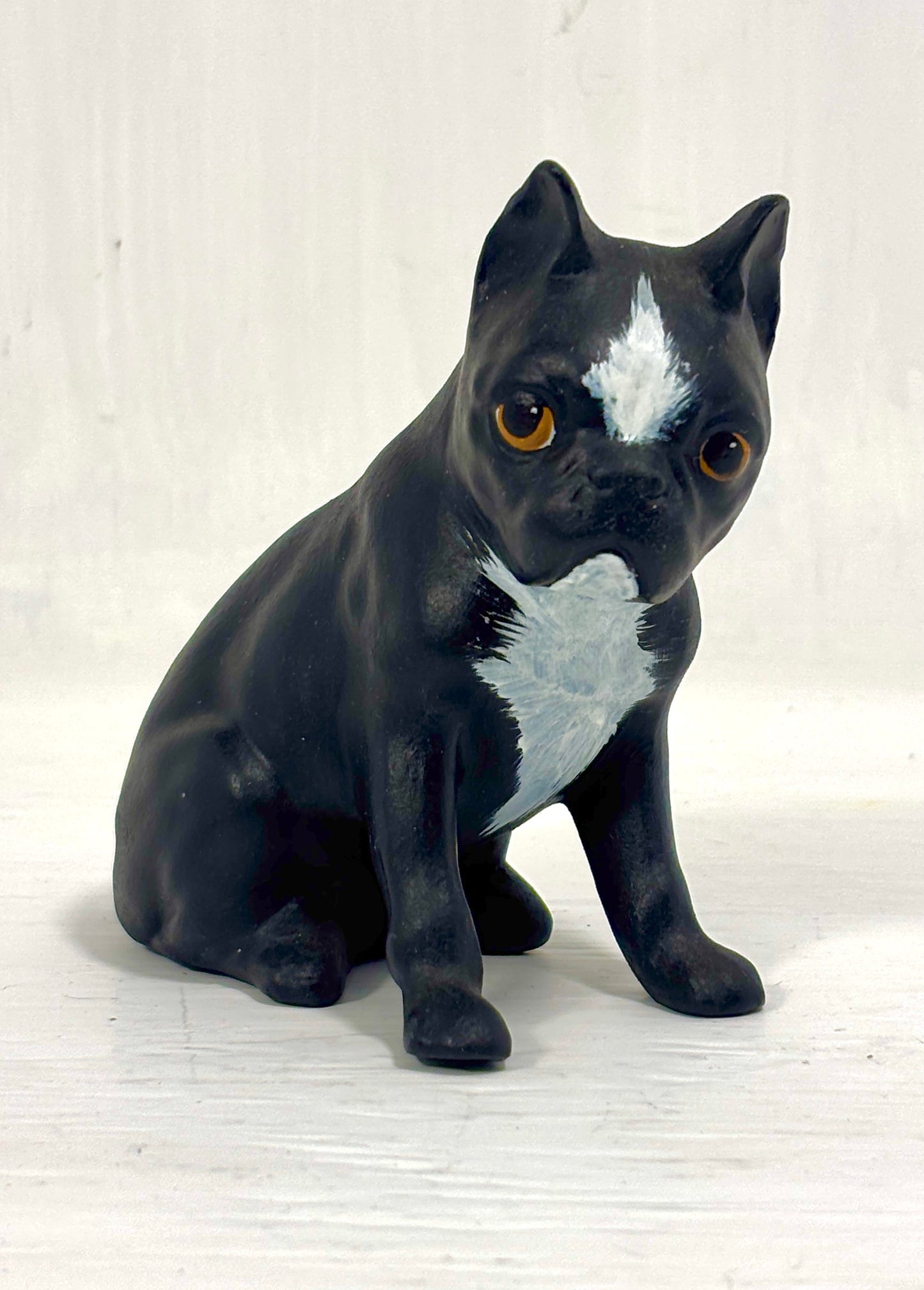 Black and white dog figurine on a light wooden surface