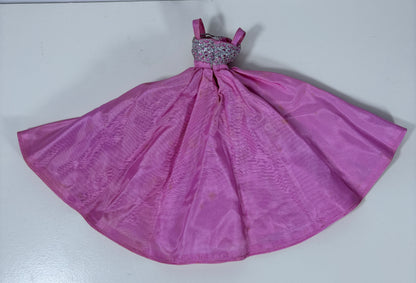 A pink dress with a wide, flared skirt and a beaded bodice, laid flat on a light gray surface.