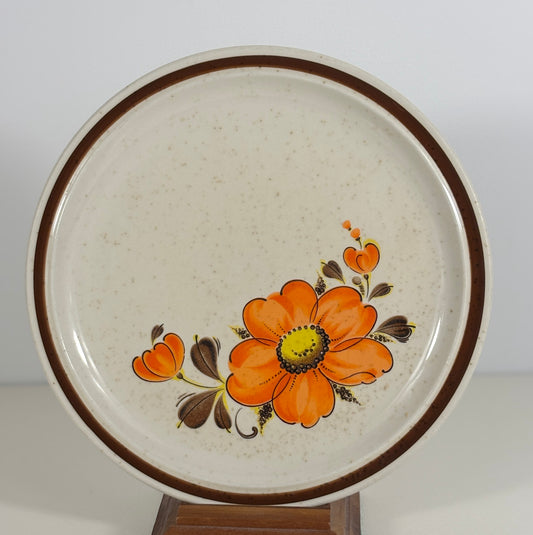 Ceramic plate with orange floral design on a white background