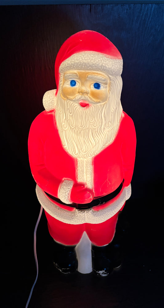 Lighted Santa Claus figure against a dark background