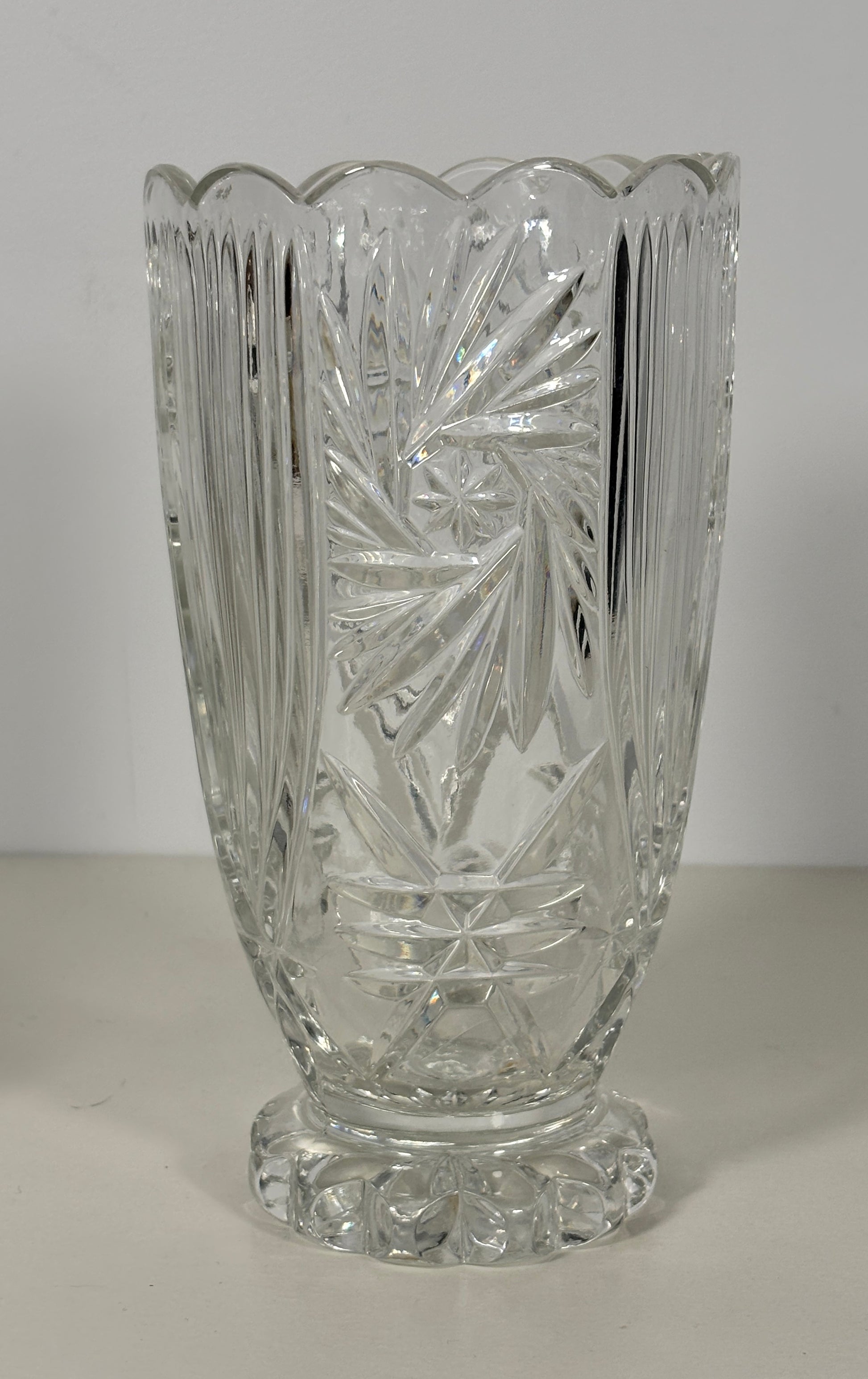 Clear glass vase with intricate cut patterns on a white background
