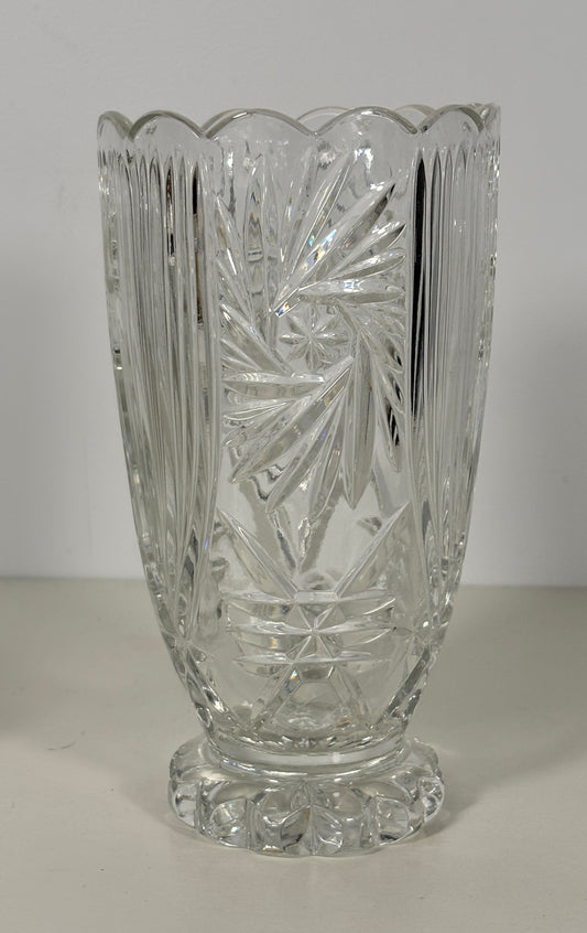 Clear glass vase with intricate cut patterns on a white background