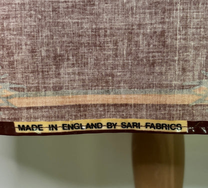 Textile with a label indicating 'Made in England by Sari Fabrics' on a fabric background.