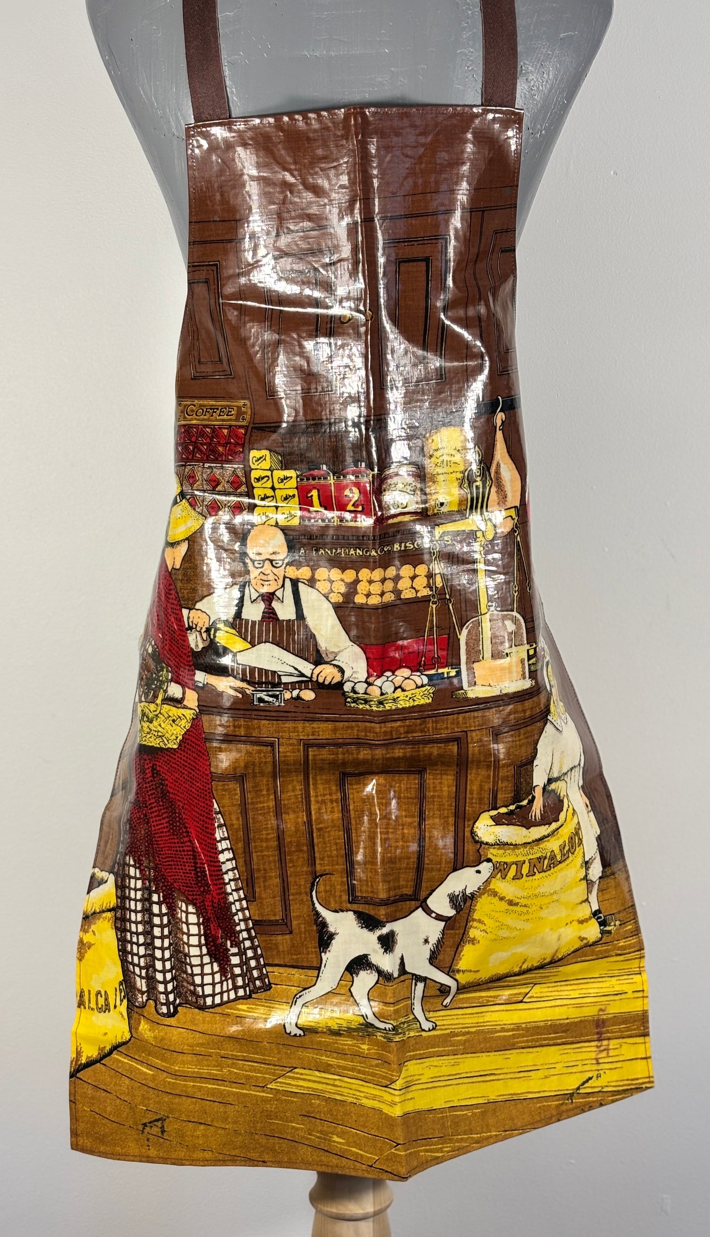 Vintage-style apron with a printed design of a market scene on a mannequin.