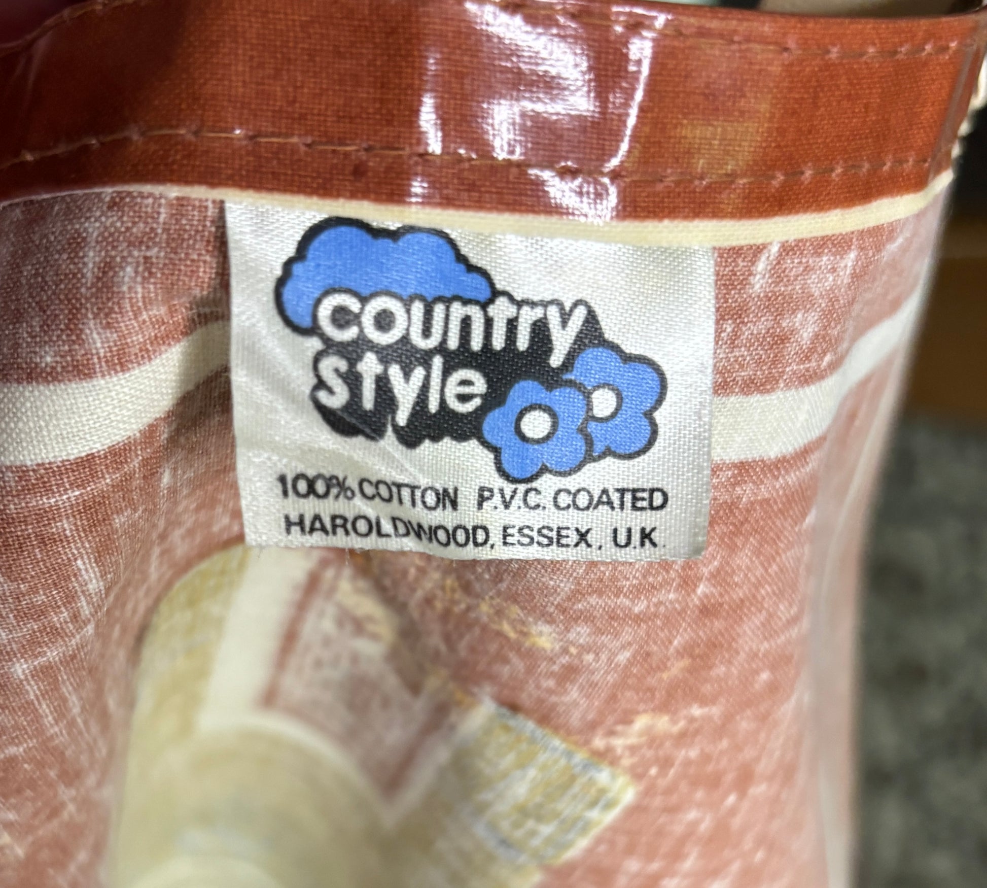 Close-up of a label on a brown and white fabric product with 'country style' branding.