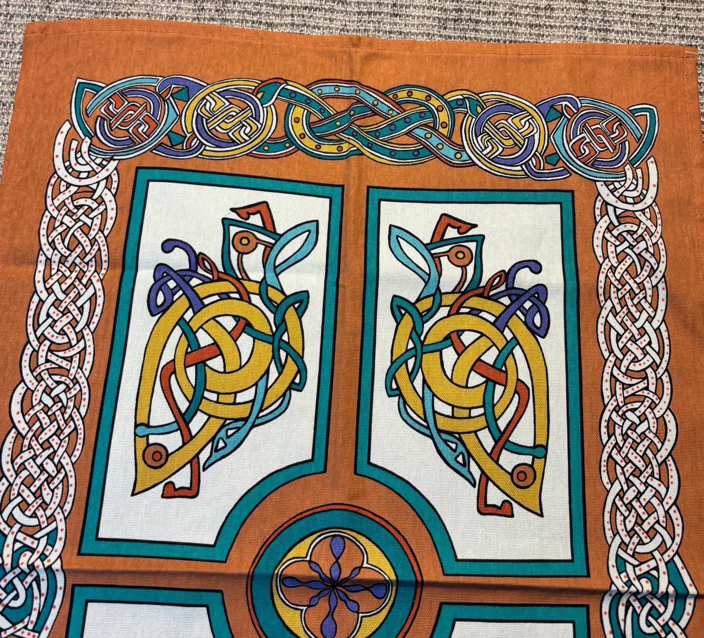 Decorative fabric with Celtic knot designs and patterns on a brown background