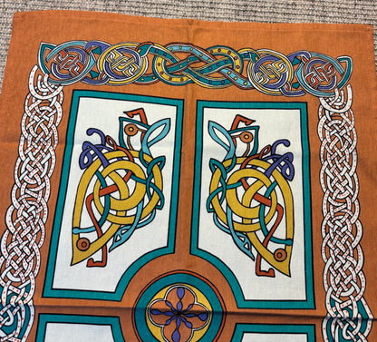 Decorative fabric with Celtic knot designs and patterns on a brown background