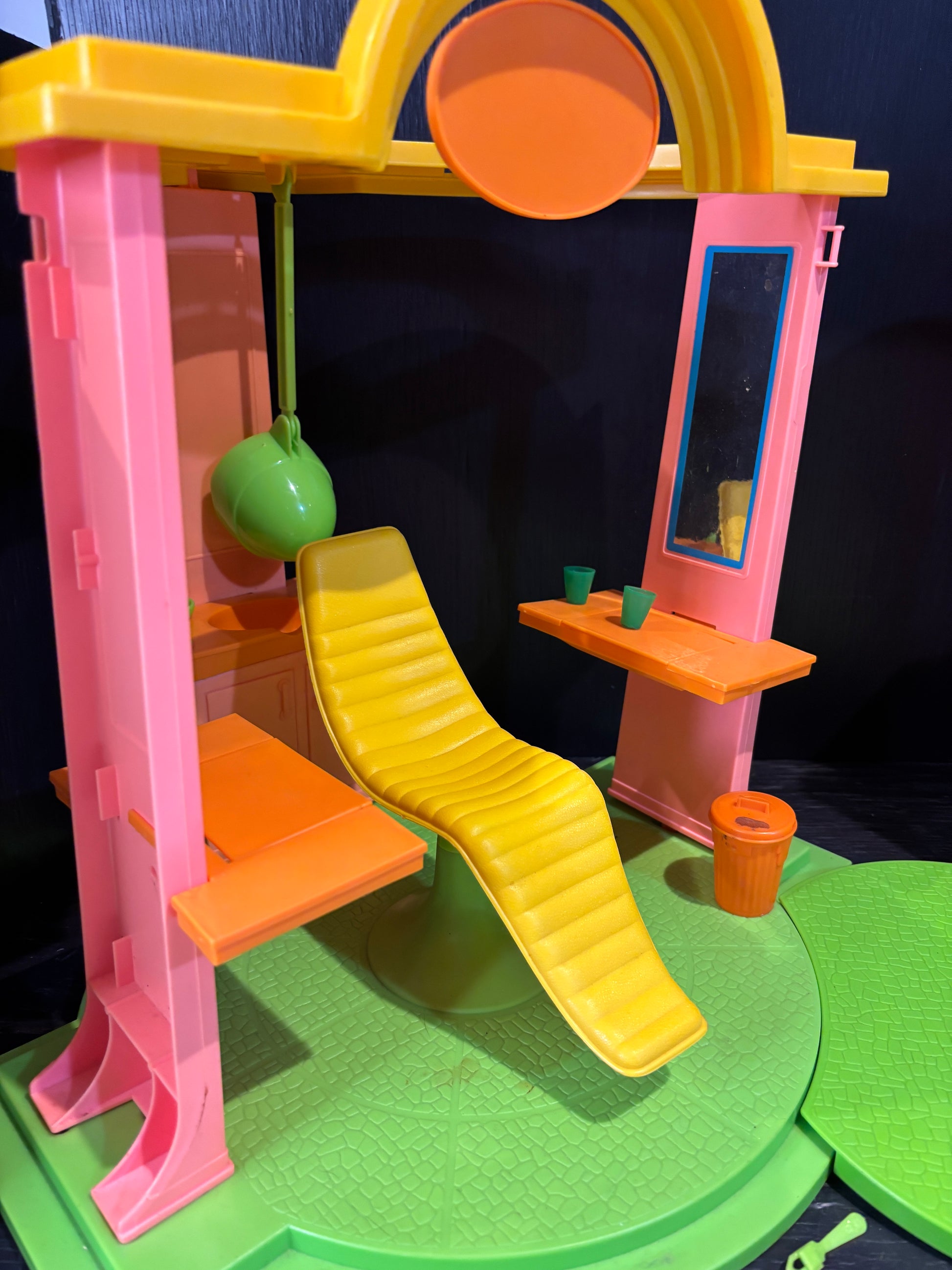 Toy track set with pink and yellow elements on a dark surface