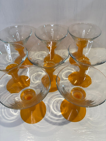 Set of clear glass tumblers with gold bottoms on a white background