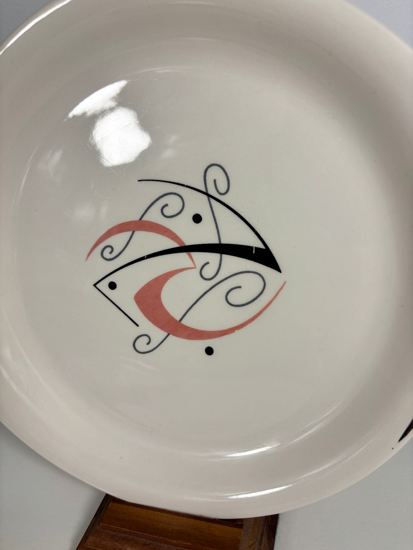 White plate with a decorative black and red design on a white background