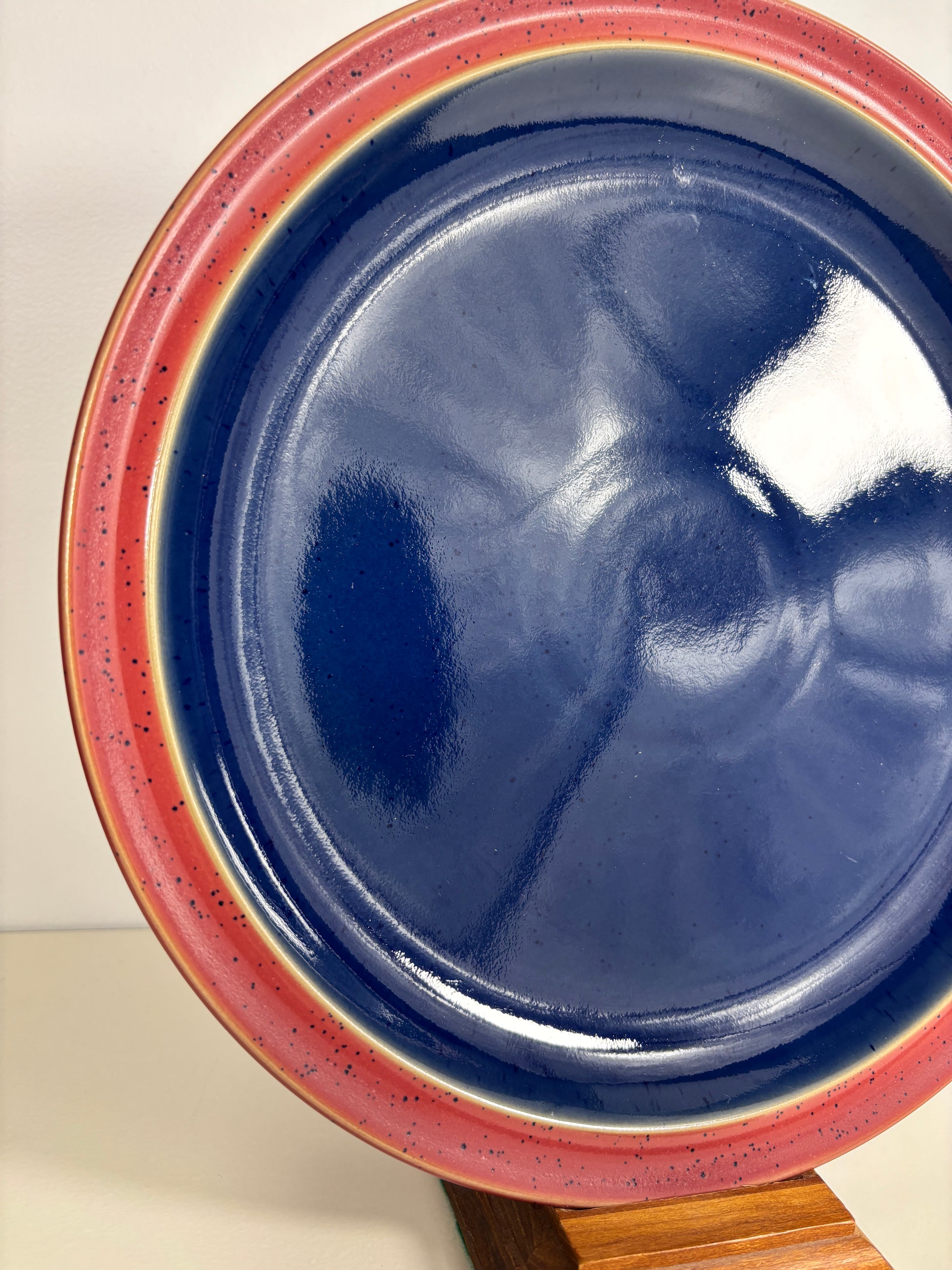 Blue ceramic dish with red interior on a white background