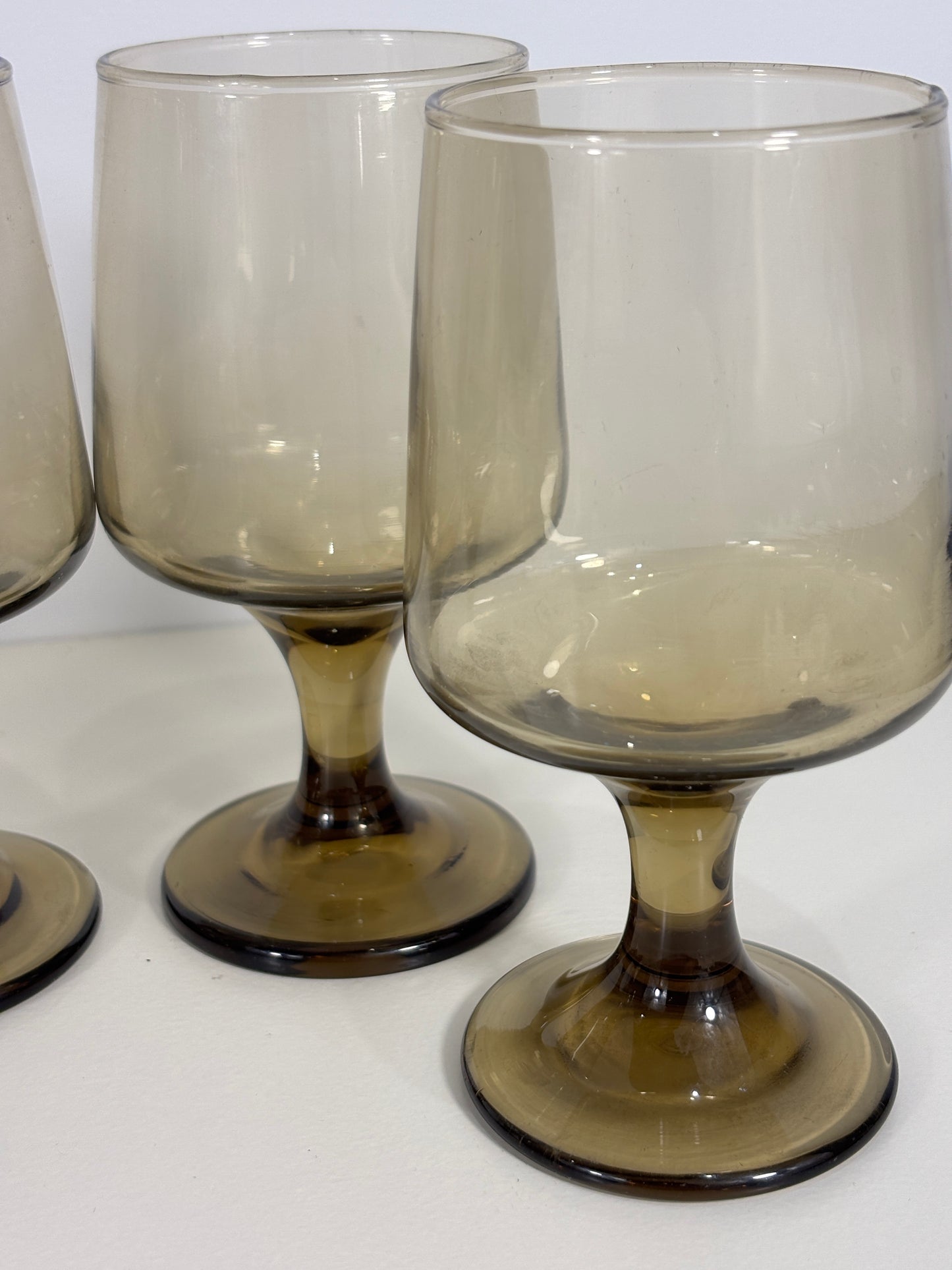Two smoked glass wine glasses on a white background