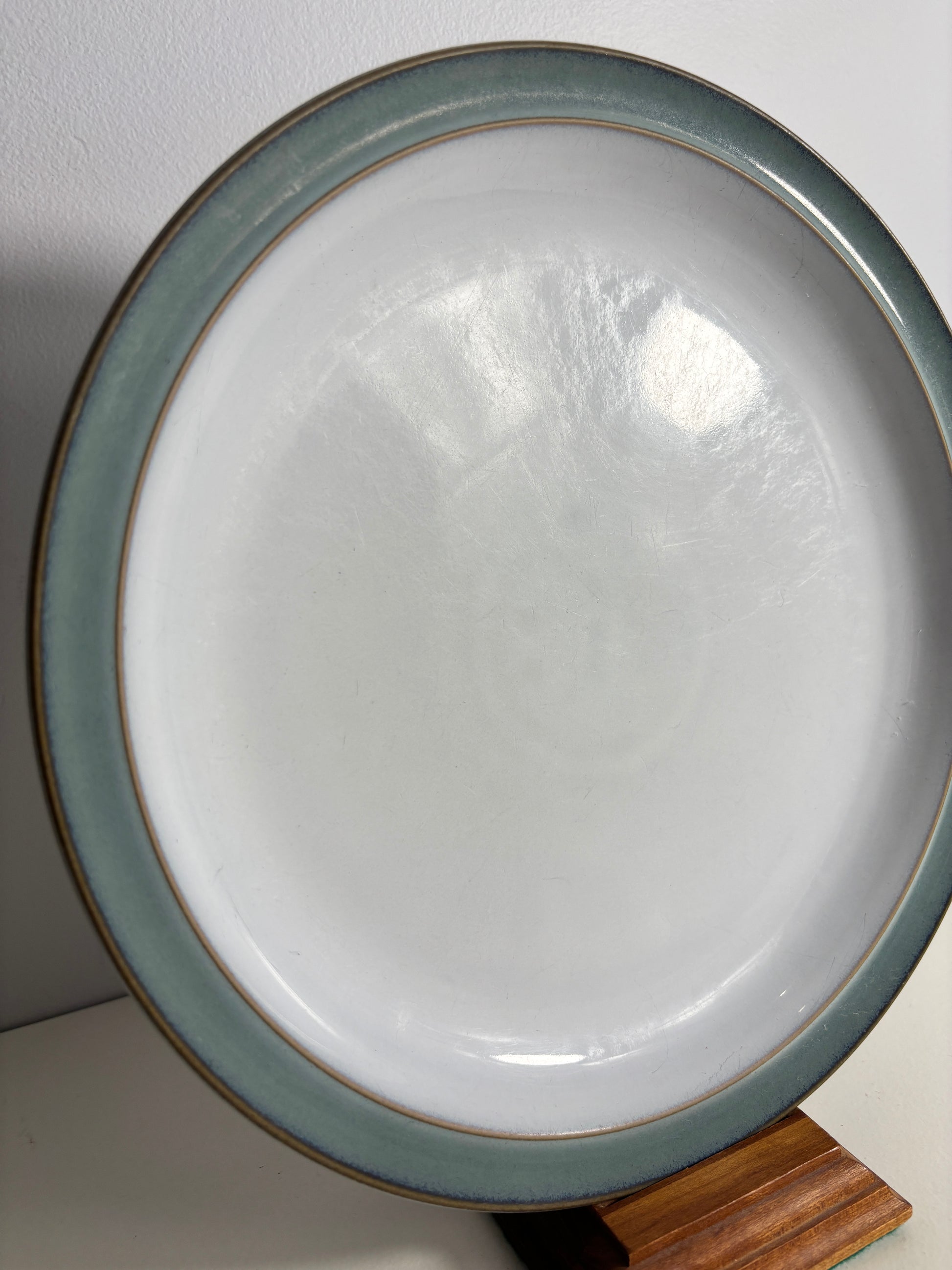 Ceramic plate with a green rim on a white surface