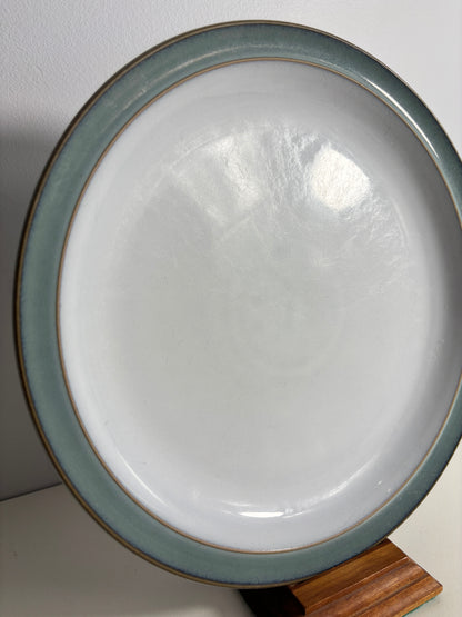 Ceramic plate with a green rim on a white surface