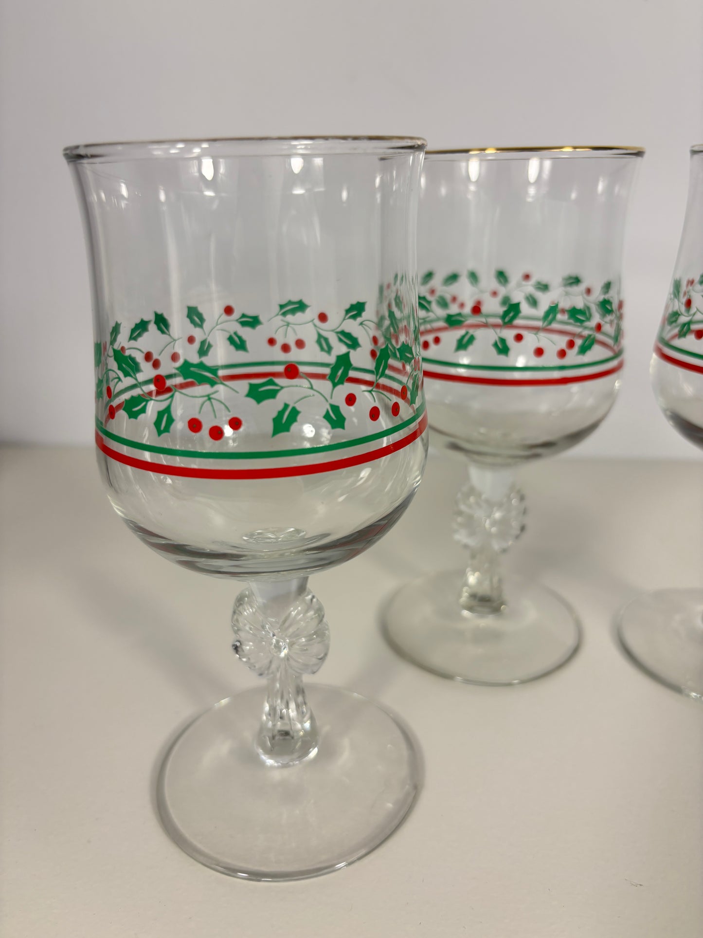 Clear glass tumblers with red and green decorative bands on a white background