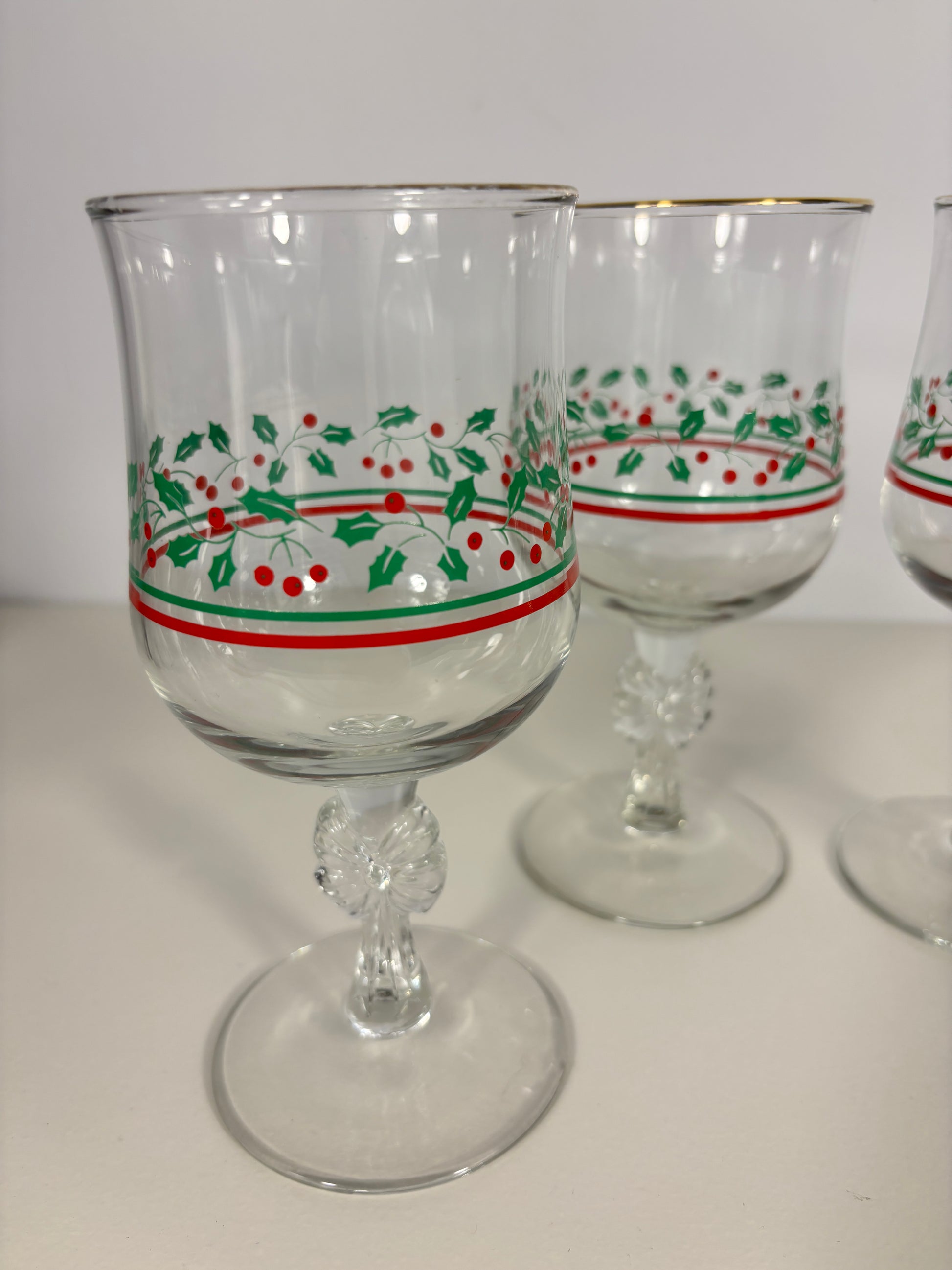 Clear glass tumblers with red and green decorative bands on a white background