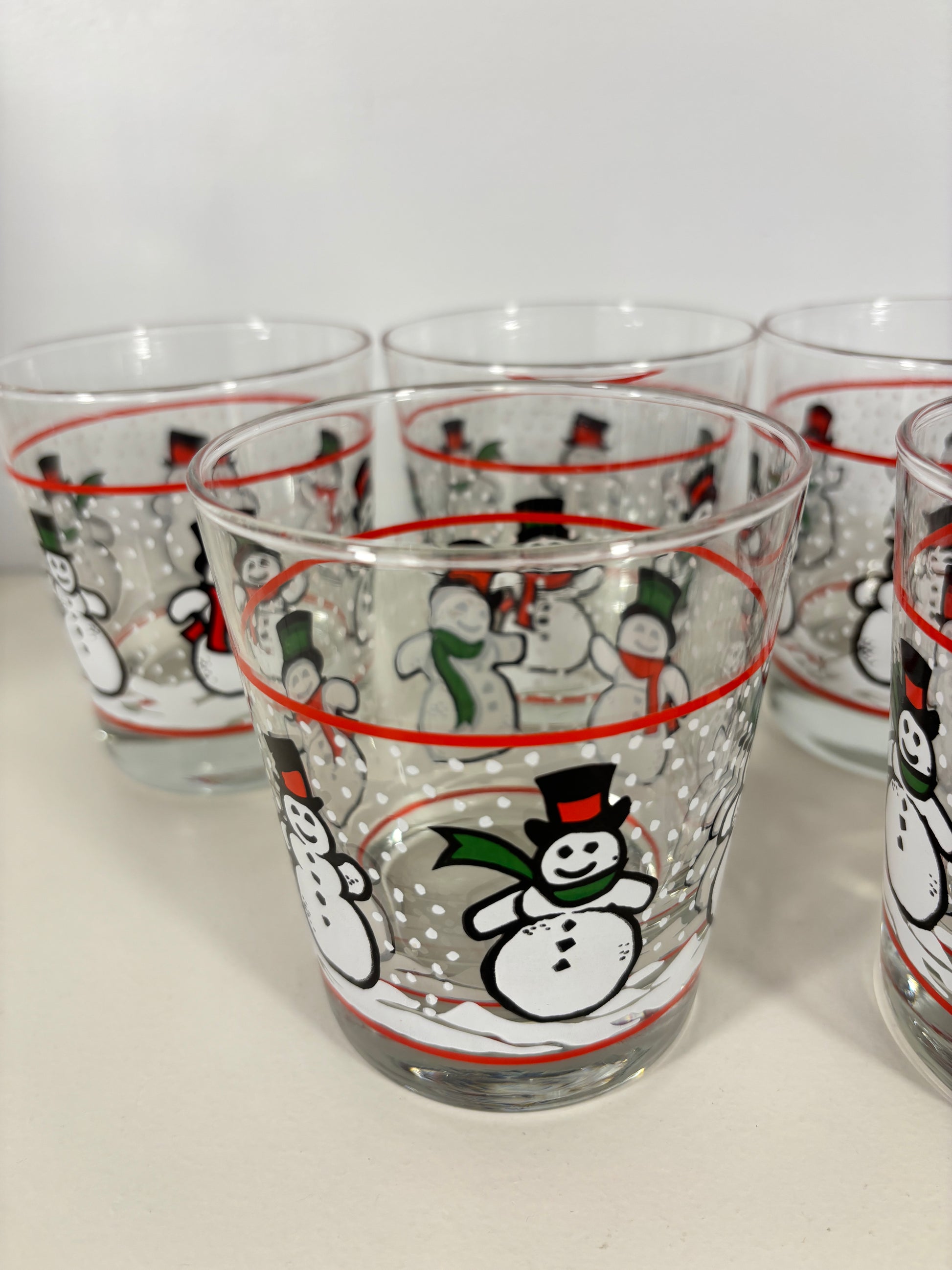 Set of clear glasses with cartoon character designs on a white background