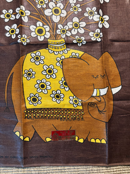 Decorative fabric with an elephant and floral design on a brown background