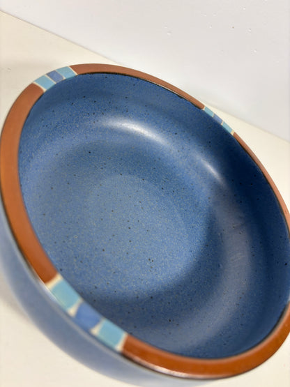 Blue ceramic dish with brown rim on a white background